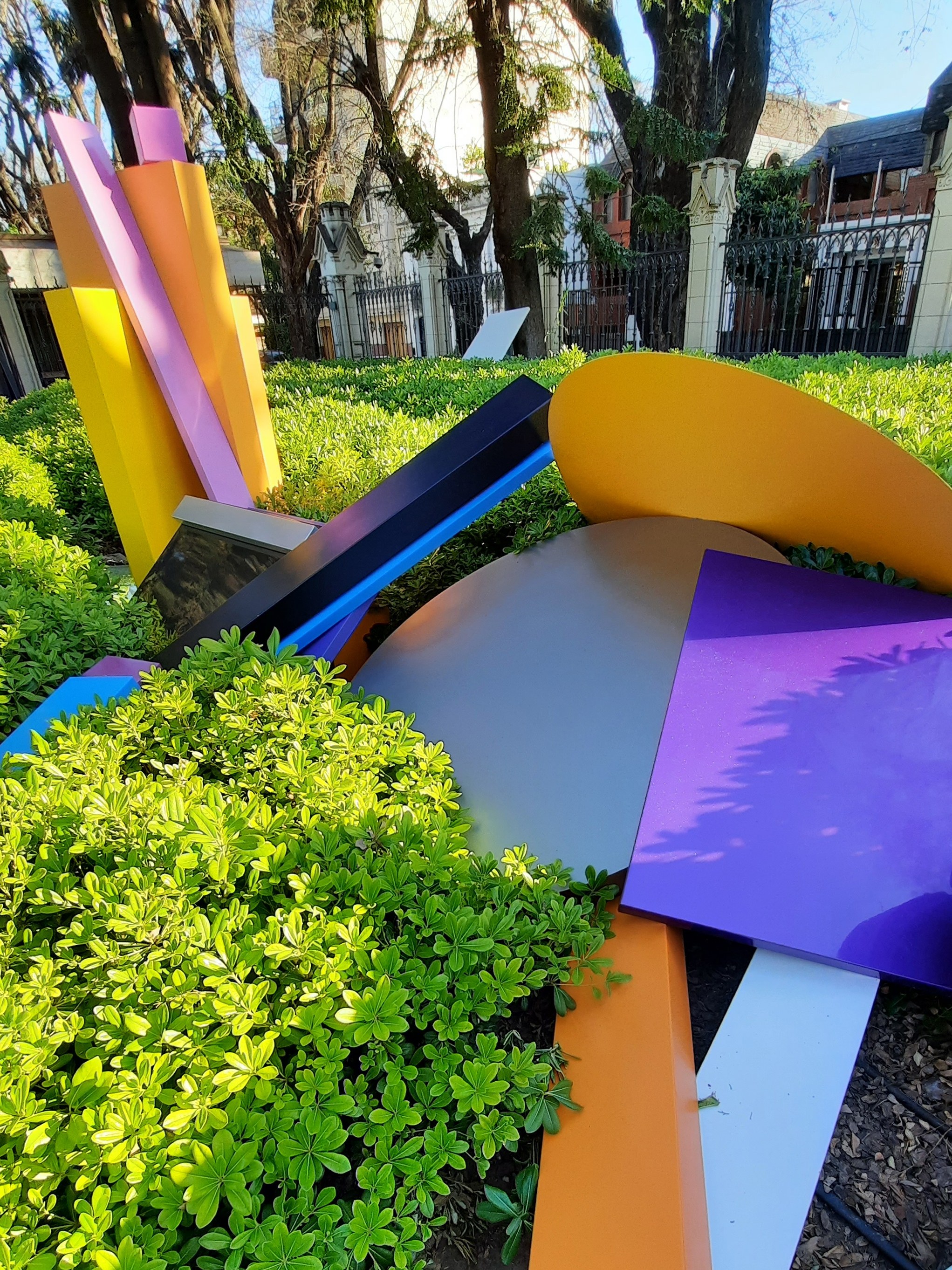 Interacción entre formas coloridas y el entorno natural de la embajada