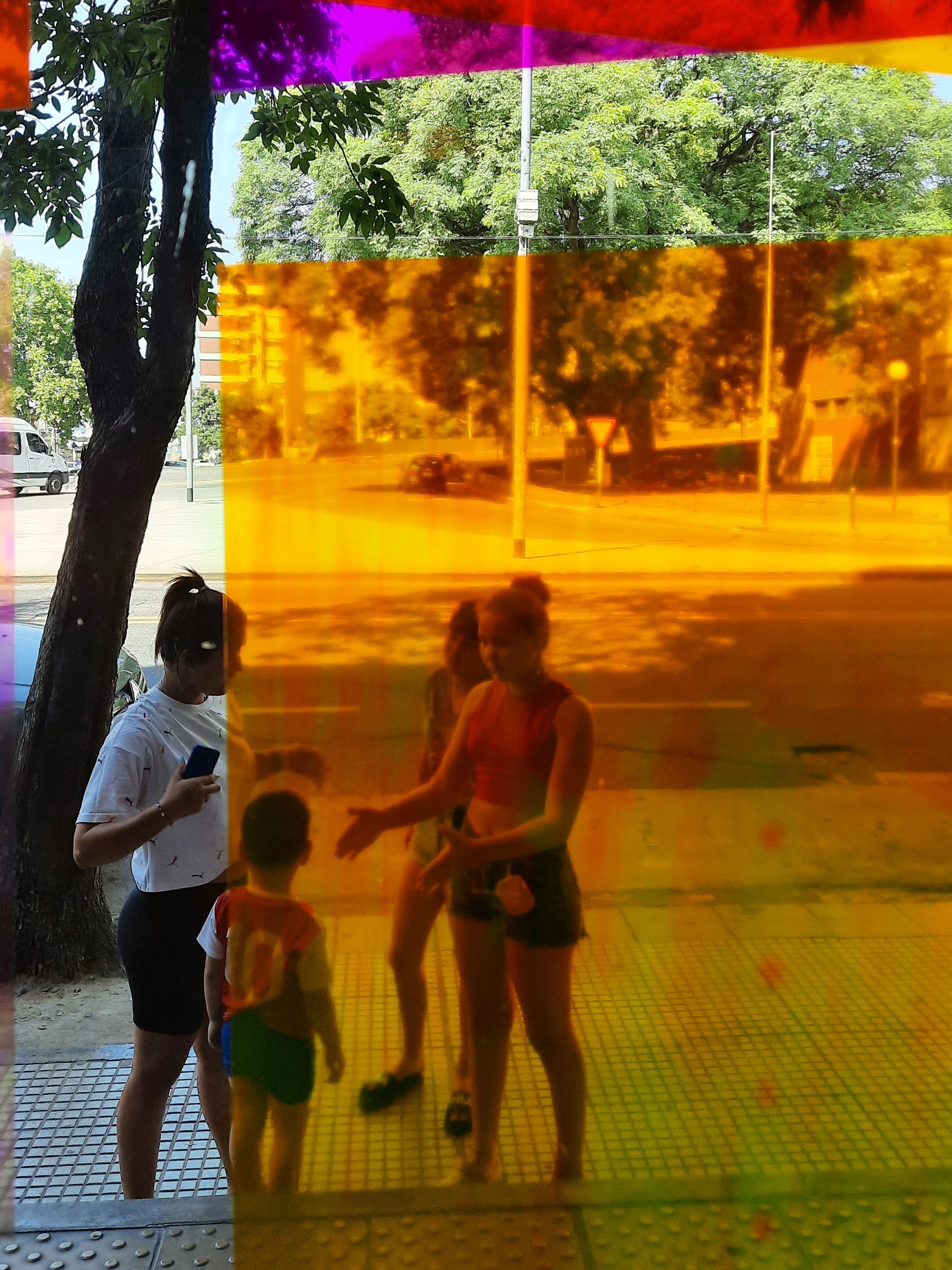 Visitantes observando la exposición desde el exterior a través de filtros amarillos, La Boca
